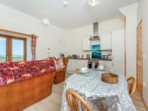 a living room with a table and a couch at The Barn Mey in Scarfskerry +10 photos