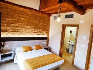 a bedroom with a bed with white sheets and orange pillows at Hostal Restaurante LA SENDA in Camponaraya