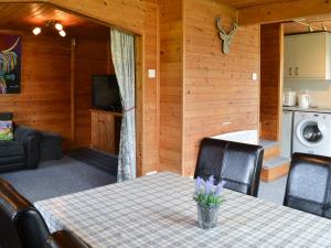a dining room with a table and a living room at Loch Arkaig in Banavie