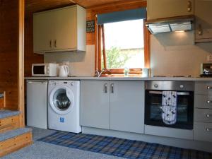 a kitchen with a washer and a washing machine at Loch Arkaig in Banavie