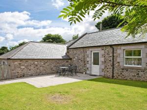 a stone building with a table and chairs in a yard at Humbleton Falls in Wooler +5 photos
