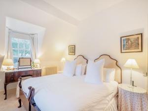 a bedroom with a large white bed and a window at Rhoda's Cottage in Strachur +15 photos