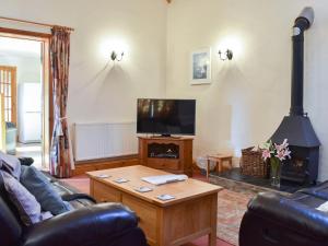 a living room with a couch and a fireplace at Ricann - Ukc4244 in Lanreath