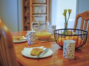 a wooden table with a glass pitcher of orange juice at Cartref in Llysfaen +10 photos