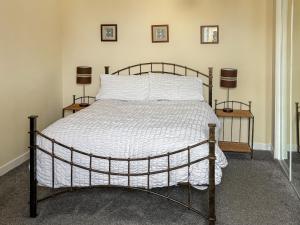a bed in a bedroom with two lamps on two tables at Ivydene Cottage in Cromarty +12 photos