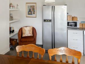 a kitchen with two chairs and a refrigerator at Ivydene Cottage in Cromarty