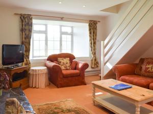 a living room with a couch and a chair and a tv at Holly - Ukc4243 in Lanreath