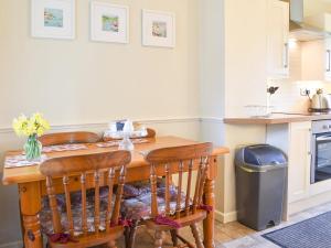 a kitchen with a wooden table and some chairs at Holly - Ukc4243 in Lanreath
