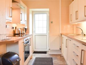 a kitchen with a door and a sink and a stove at Holly - Ukc4243 in Lanreath