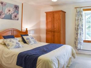 a bedroom with a bed with blue and white sheets at Holly - Ukc4243 in Lanreath +15 photos