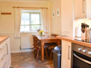 a kitchen with a wooden table and a window at Holly - Ukc4243 in Lanreath