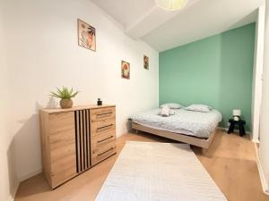 a bedroom with a bed and a dresser at Le Nid Laonnois Apartment in Laon