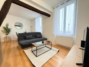 a living room with a couch and a table at Le Nid Laonnois Apartment in Laon