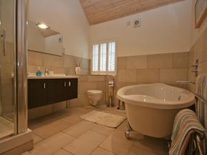 a bathroom with a tub and a toilet and a sink at Glenfruin Lodge in Helensburgh