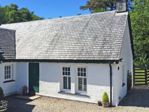 a white cottage with a gray roof at Glenfruin Lodge in Helensburgh