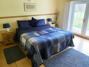a bedroom with a bed with a blue comforter at Glenfruin Lodge in Helensburgh