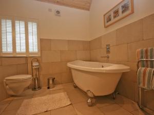 a bathroom with a tub and a toilet at Glenfruin Lodge in Helensburgh