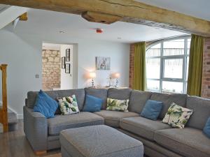 a living room with a gray couch and blue pillows at The Granary Uk13197 in Butterwick