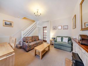 a living room with two couches and a table at Tweed Cottage in Alnwick