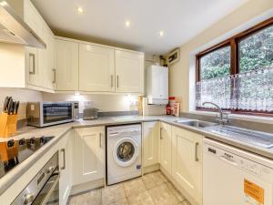 a kitchen with a washing machine and a sink at Tweed Cottage in Alnwick