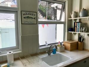 a kitchen with a sink and a window at Sea Star Cottage in Fowey +21 photos