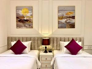 two beds in a hotel room with purple pillows at Khách sạn LAVENDER - Vincom Tây Ninh in Tây Ninh