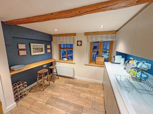 a kitchen with blue walls and a counter top at Windy Nook in Pooley Bridge