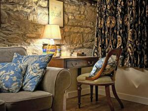 a living room with a chair and a table with a lamp at Windy Nook in Pooley Bridge