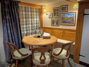 a dining room with a wooden table and chairs at Windy Nook in Pooley Bridge