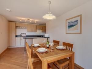 a kitchen and dining room with a wooden table and chairs at 2 Red Rock Apartments in Dawlish Warren