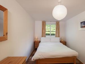a bedroom with a white bed with a window at 2 Red Rock Apartments in Dawlish Warren