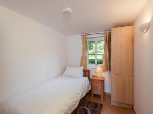 a small bedroom with a bed and a window at 2 Red Rock Apartments in Dawlish Warren +2 photos