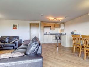 a living room with a couch and a kitchen at 14 Red Rock Apartments in Dawlish Warren