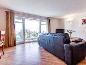 a living room with a couch and a large window at 14 Red Rock Apartments in Dawlish Warren