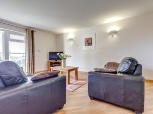 a living room with two couches and a television at 14 Red Rock Apartments in Dawlish Warren