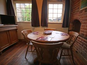 a dining room with a table and a fireplace at Spring Farm Barn in Grindale