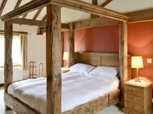 two wooden beds in a bedroom with red walls at Spring Farm Barn in Grindale +6 photos