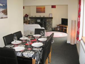 a dining room with a table with wine glasses on it at Springer Cottage in Llanstephan