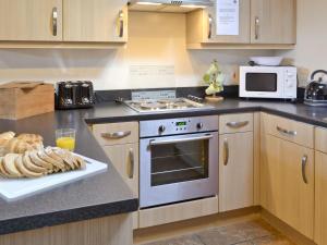 a kitchen with a stove and a plate of bread at Padgett Lodge - 23052 in Folkton