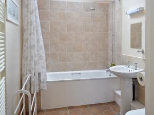a bathroom with a sink and a bath tub and a toilet at Padgett Lodge - 23052 in Folkton