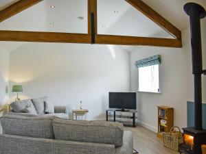 a living room with a couch and a tv at The Dairy Uk13198 in Butterwick