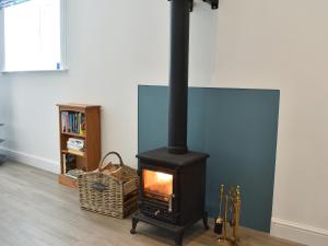 a black stove in a room with a book shelf at The Dairy Uk13198 in Butterwick