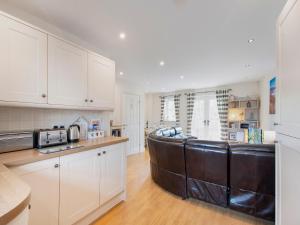 a kitchen with a leather couch in the middle at Harbour Retreat in Garlieston