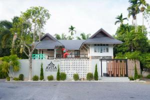 a house with a white fence in front of it at Avita Pool Villa in Sichon