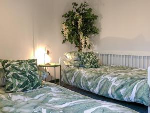 a room with two beds and a plant on the wall at Bertram Cottage in Swarland +5 photos