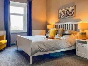 a bedroom with a white bed and a window at Bertram Cottage in Swarland