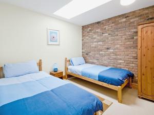 a bedroom with two beds and a brick wall at Close Cottage - W41944 in Filey