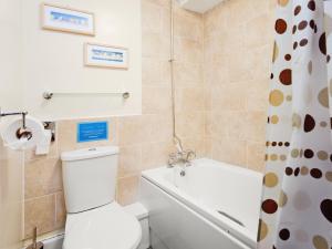 a bathroom with a toilet and a bath tub at Close Cottage - W41944 in Filey