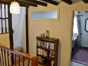 a hallway with a book shelf with books at Brock Cottage in Broughton in Furness