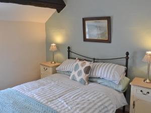 a bedroom with a bed with two night stands and two lamps at Brock Cottage in Broughton in Furness +3 photos